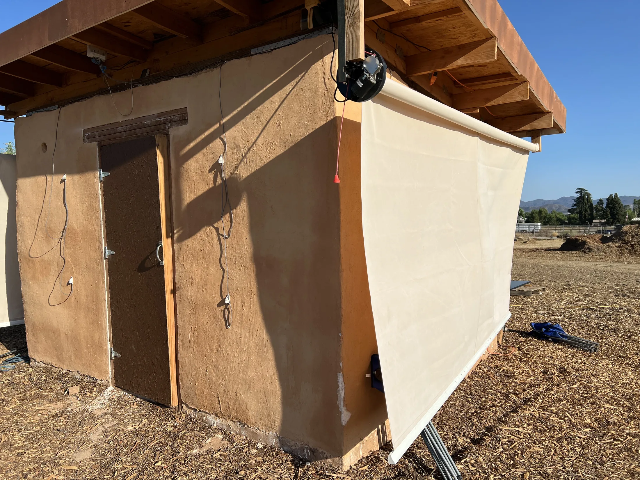 Exterior of a Littlest Big Farm showing earthen construction and retractable shade system
